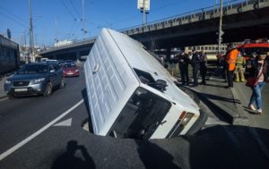 В Киеве микроавтобус “утонул” в яме посреди дороги